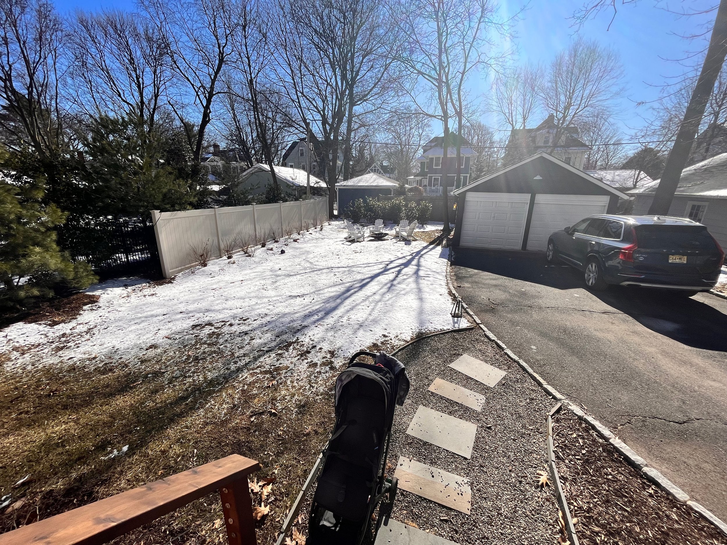 uninspired backyard with garage and driveway cutting into usable space