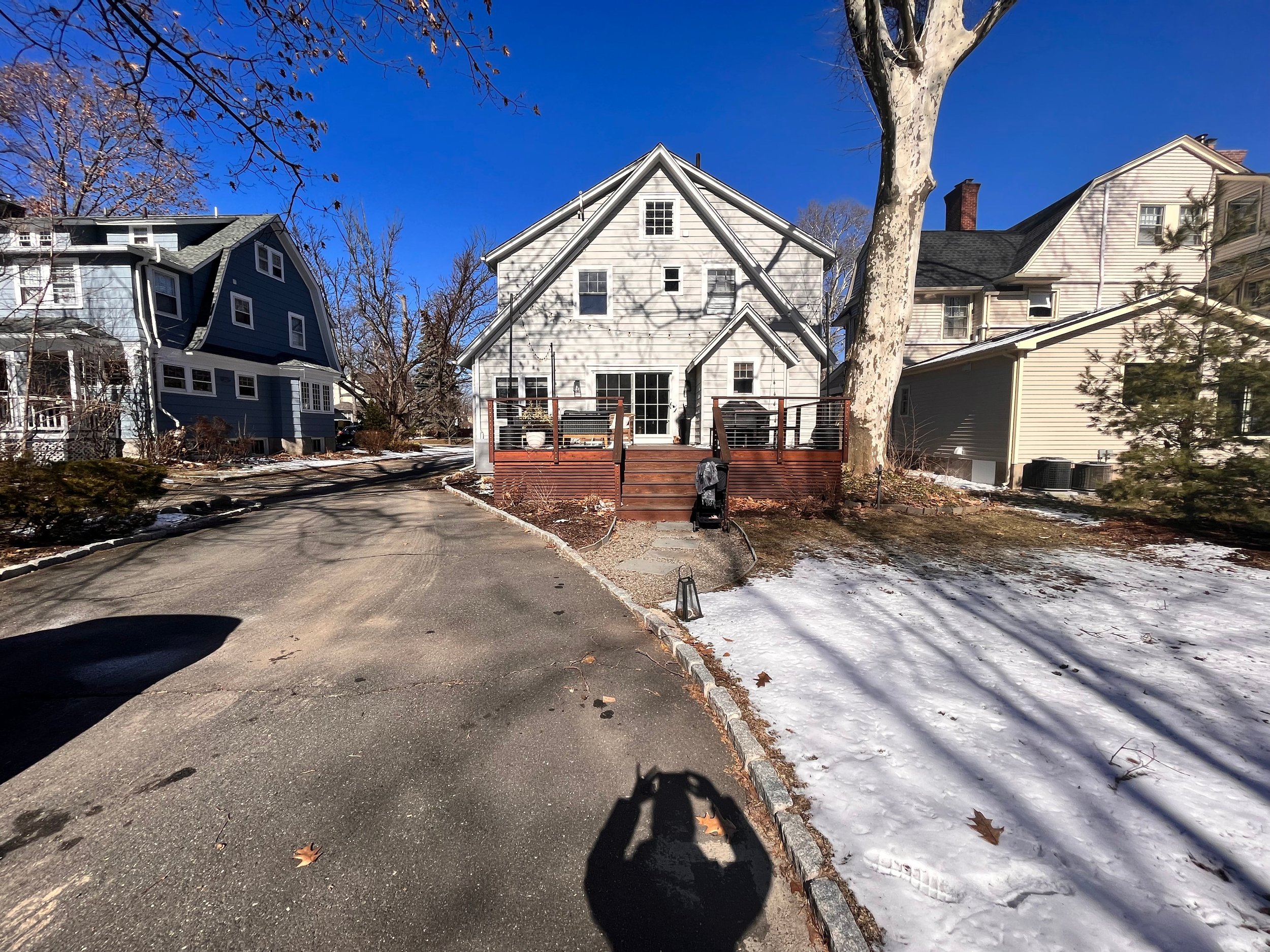 uninispired backyard with curving driveway that cuts into lawn